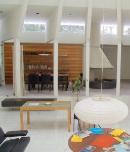 Dining Room: Front Entry:Looking across the atrium toward the dining area, where the roof supports form a colonnade and the clerestory windows are visible.