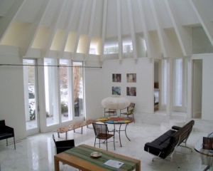 Living Room: With its white marble floor and tall ribbed ceiling, the room feels like both a temple and a tent. To the south it opens to a patio and the large garden. Across the room it opens to the master suite on the left, and to the far right there is a closable slit opening into one of the children’s bedrooms. The windows in the center look into the private courtyard.