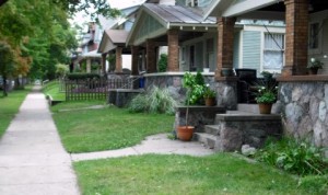 A traditional medium-density urban residential neighborhood with porches, compact homes, alleys in the rear, sidewalks, and retail areas within walking distance.